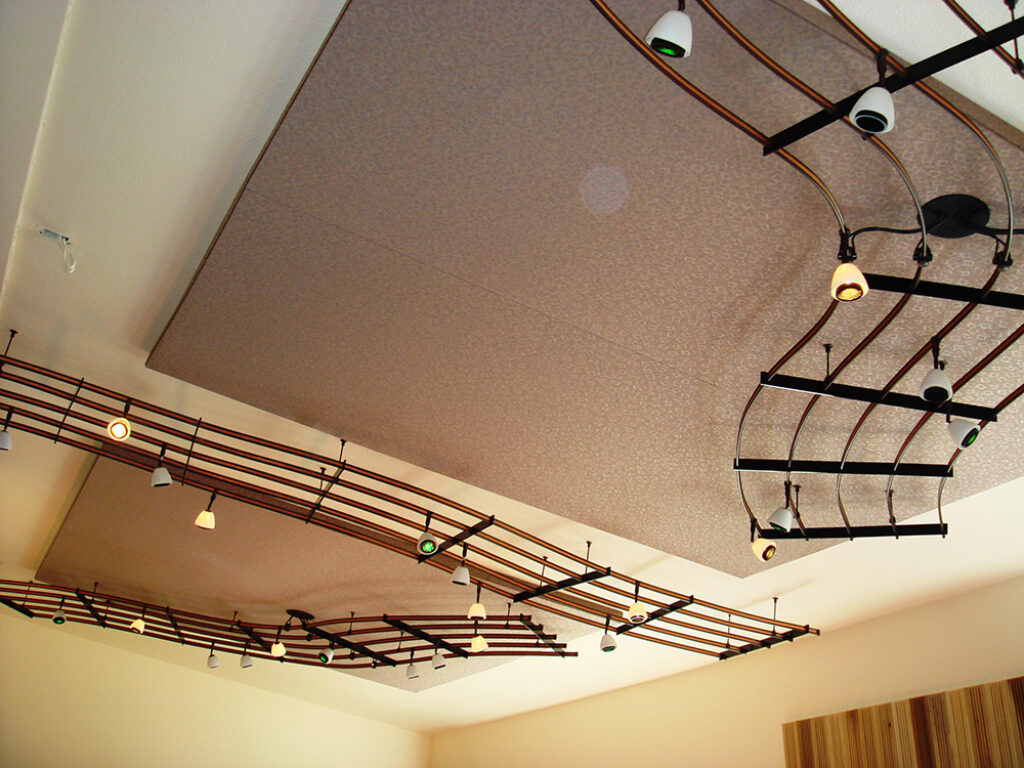 An image of a custom lighting installation that looks like bars of sheet music on the ceiling