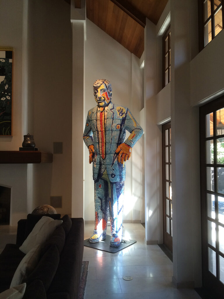 an image of a suited man sculpture with strategic lighting around it